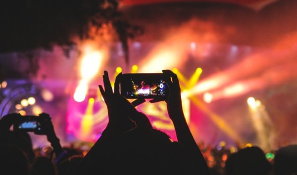 person holding phone at a concert