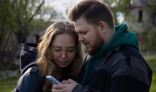 man and woman looking at phone